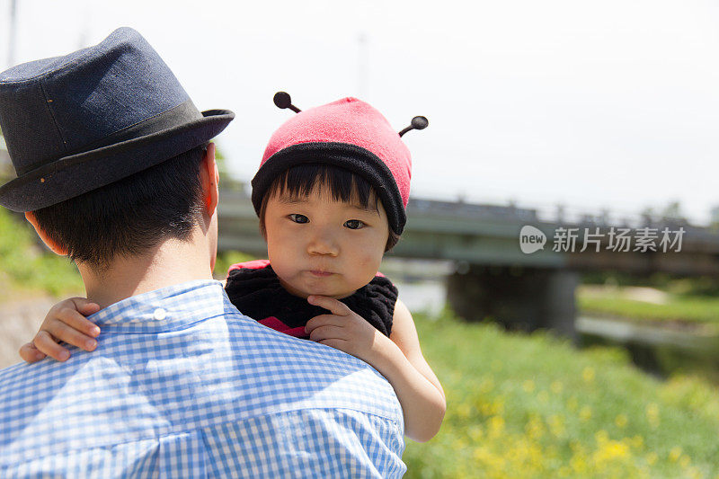 年轻的父亲和他可爱的女儿穿着瓢虫装