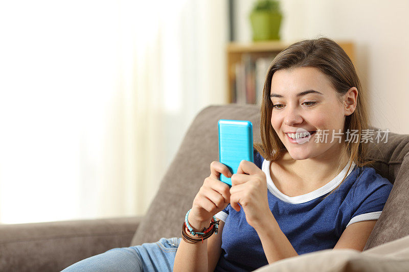 青少年在家里使用蓝色智能手机