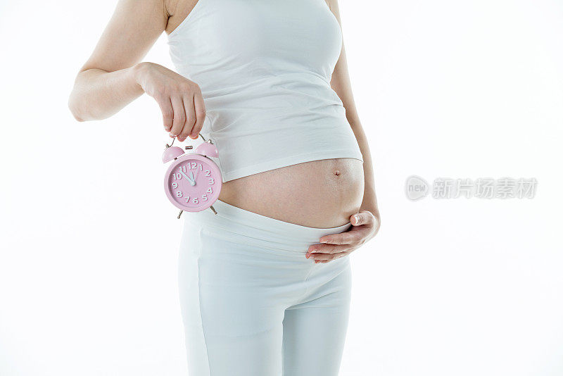 一个孕妇把闹钟放在肚子上