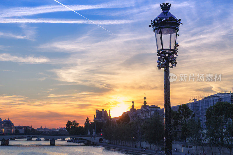 从艺术桥上俯瞰法国巴黎塞纳河上的戏剧性日落。