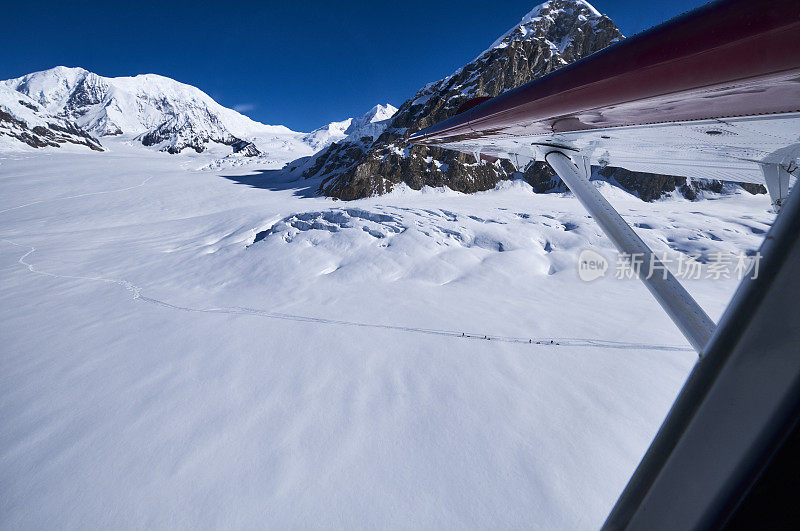 德纳里从飞机窗口向空中拍摄了冰川和山脉上的徒步旅行者。