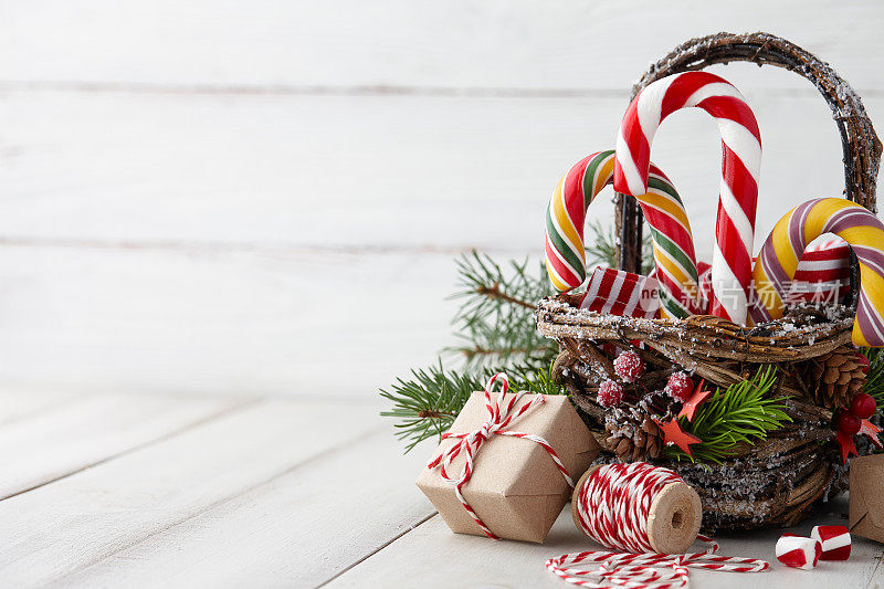 白色木板上挂着拐杖糖的圣诞篮子