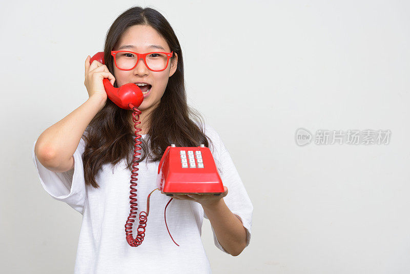 年轻美丽的亚洲女人穿着白色衬衫对抗白色背景