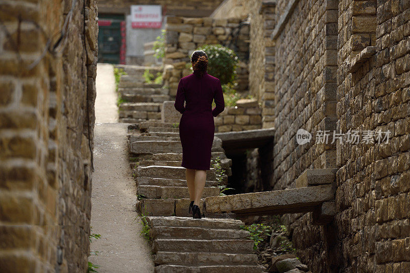 穿着中国传统旗袍的妇女在古村落里拍照