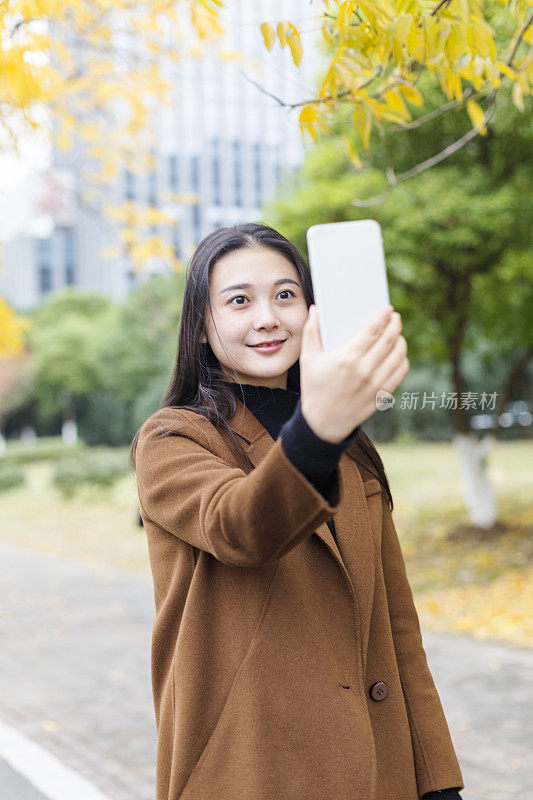 年轻女子在城市街道上自拍