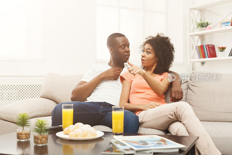 一对吓坏了的非洲裔美国夫妇在家里看电视