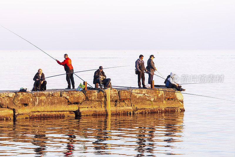 在俄罗斯索契的黑海，渔民们用钓竿捕鱼