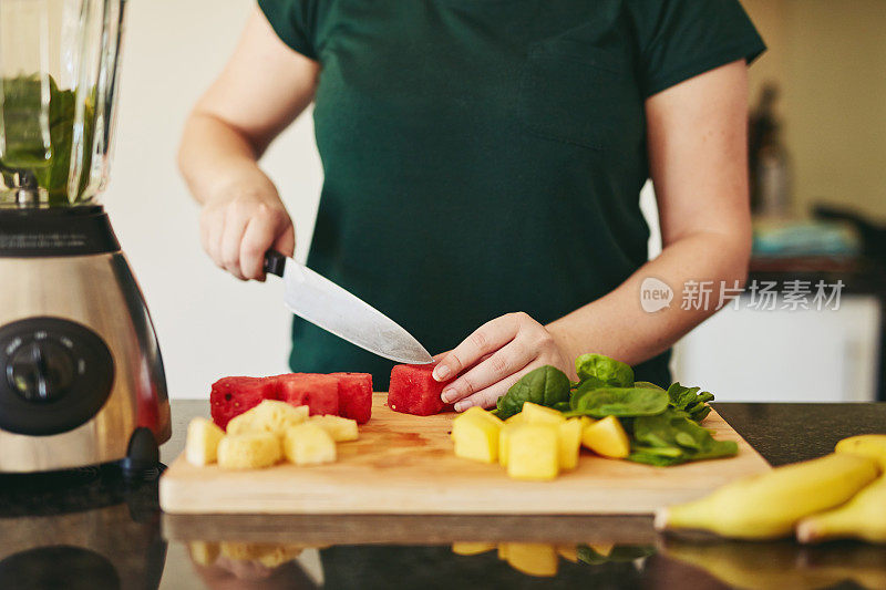 一个不认识的女人切水果的特写镜头，同时做冰沙