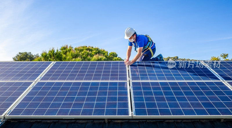 太阳能电池板安装工在现代住宅的屋顶上安装太阳能电池板