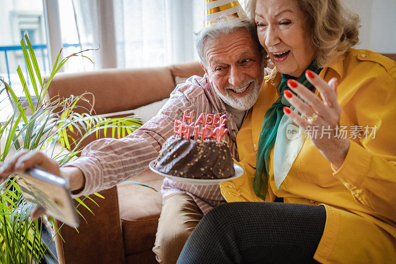 兴奋的老夫妇正在举办生日派对并自拍