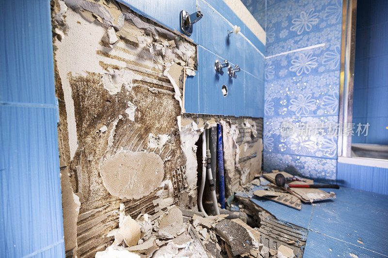 浴室墙壁上的瓷砖已被撕下——湿的石膏板墙上有霉菌
