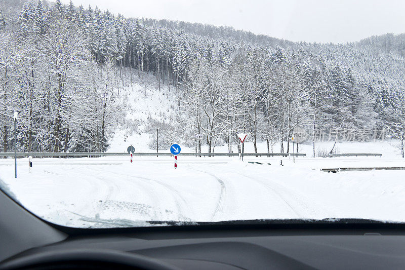 冬天的情况，一辆车在结冰的弯道上接近十字路口