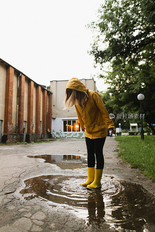 一个女人穿着防水衣服在水坑上玩