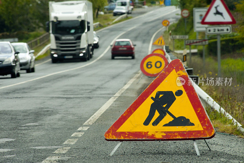 道路施工标志，卡车通过，前方危险警告，限速。