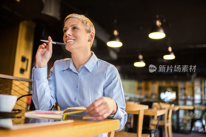 女商人在咖啡店工作和思考。