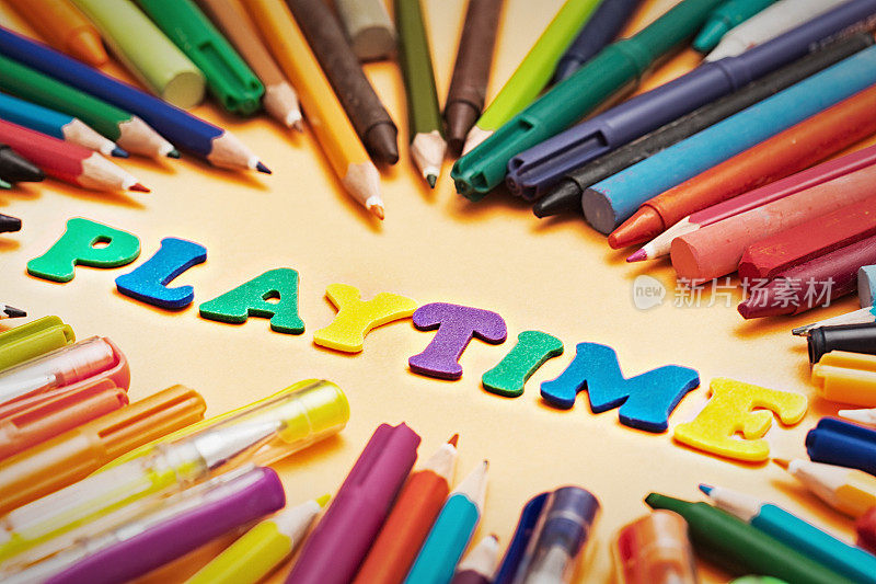 游戏时间，孩子们的游戏字母被许多彩色钢笔和铅笔包围着