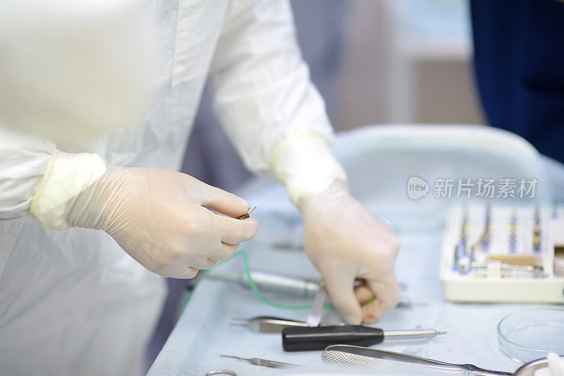 正畸外科医生是在牙科手术中植入。临床拔牙后种植体的安装。