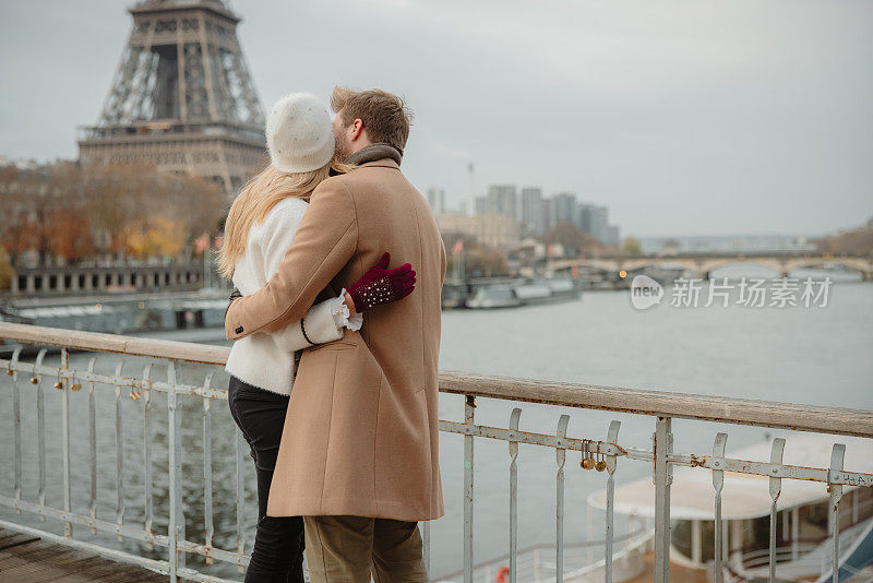在巴黎埃菲尔铁塔的背景下，一对浪漫的情侣在塞纳河上拥抱亲吻