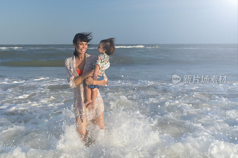 母亲和她的孩子在海滩上玩