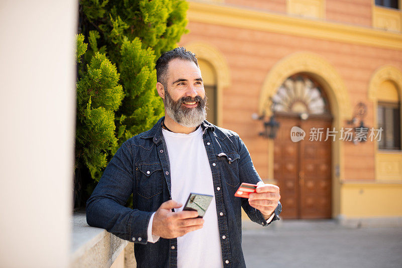 英俊的中年男子在城市里度假购物