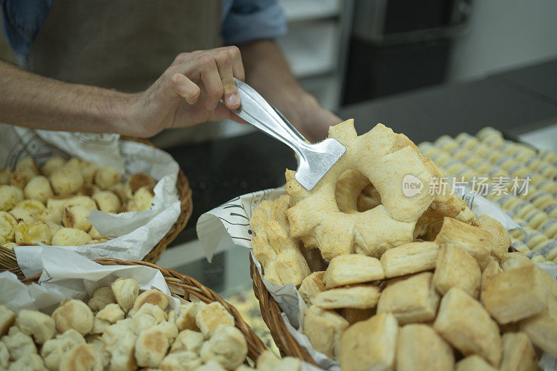 近距离的面包店员工安排“cremona”糕点在柜台的展示篮子