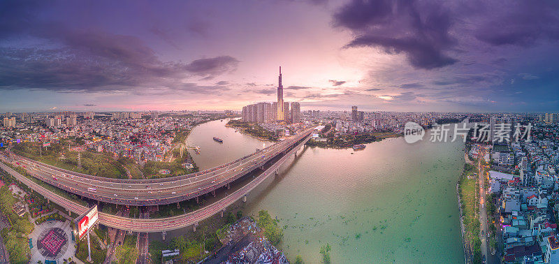 从空中俯瞰81号地标的日落景观——一幢超高的摩天大楼和西贡大桥，西贡河沿岸的发展在光线下十分流畅