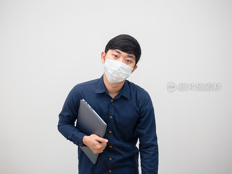 亚洲男子戴着防护口罩感到恶心和低能量的工作概念手中拿着笔记本电脑白色背景
