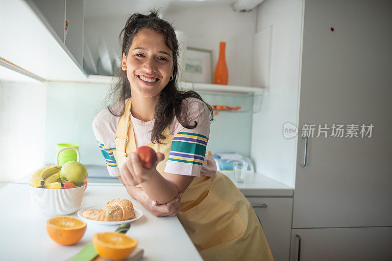 一个年轻微笑的女人正在吃健康的早餐