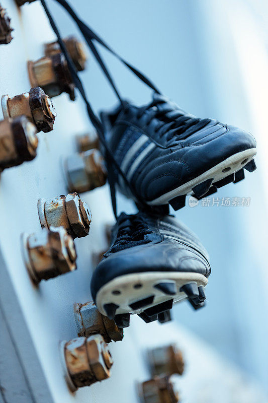 足球鞋挂在金属结构上。