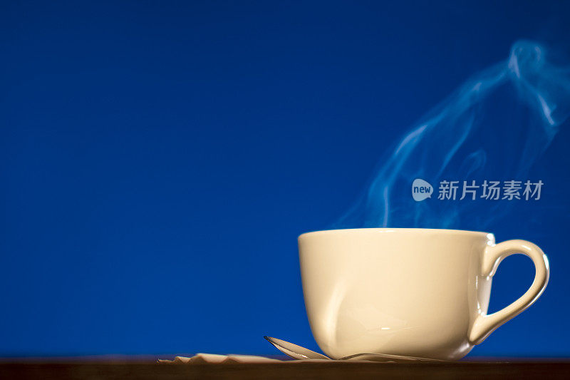 在蓝色背景下，一大杯咖啡或茶中冒出的蒸汽