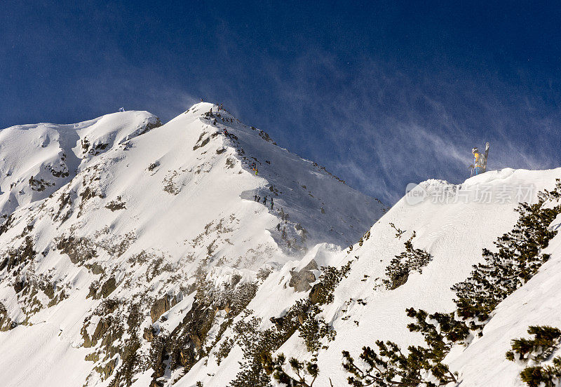 在一个多风的冬日里，乡村滑雪者在攀登山脊