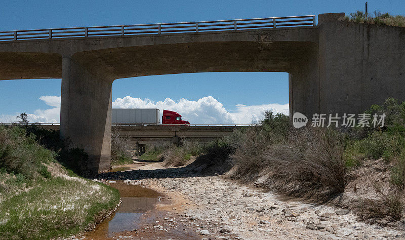 半挂车停在沙漠州际立交桥上，下面是一条小溪。犹他州70号州际公路。