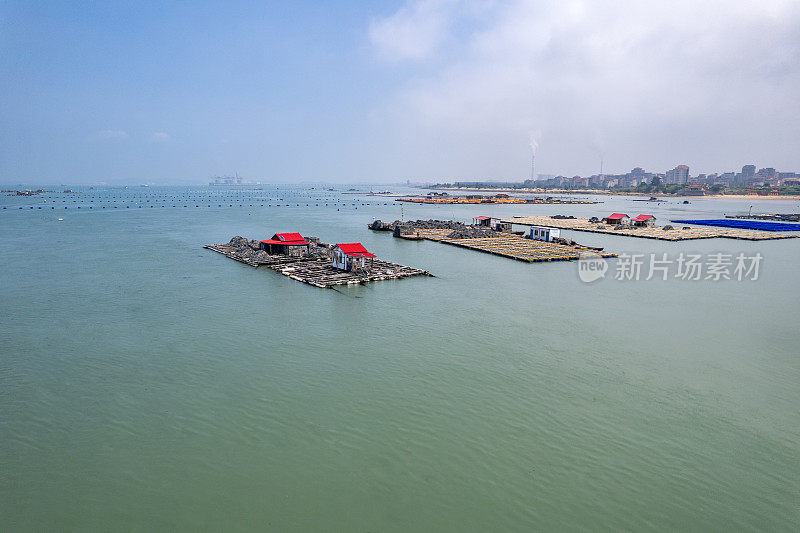 在一个阳光明媚的日子里，在海上鸟瞰水产养殖场