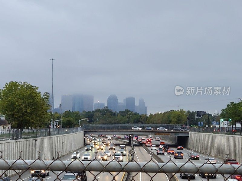 高速公路上的交通和休斯顿市中心的天际线被云包围