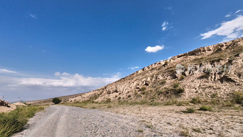 在泥泞的道路上行驶，穿过山麓的沙岩。汽车的观点