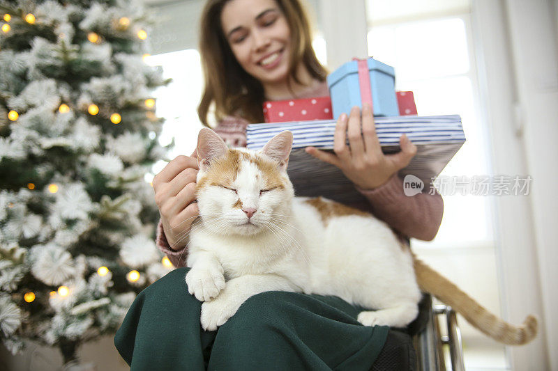 年轻女子和她的猫一起庆祝节日