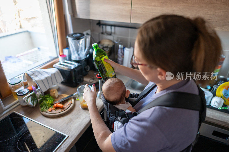 母亲用搅拌器给婴儿准备食物