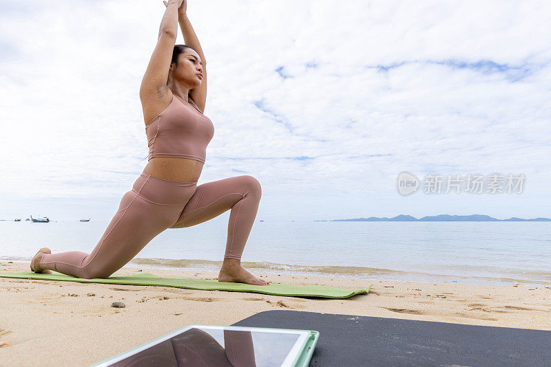 一位泰国妇女在海滩上做瑜伽