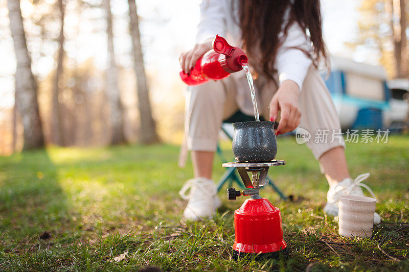 一个女人在户外露营时煮咖啡的特写