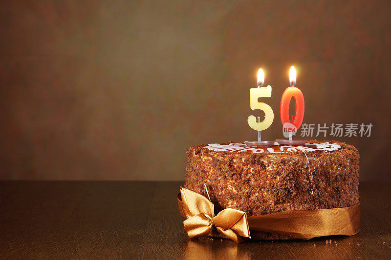 生日巧克力蛋糕和燃烧的蜡烛作为数字50