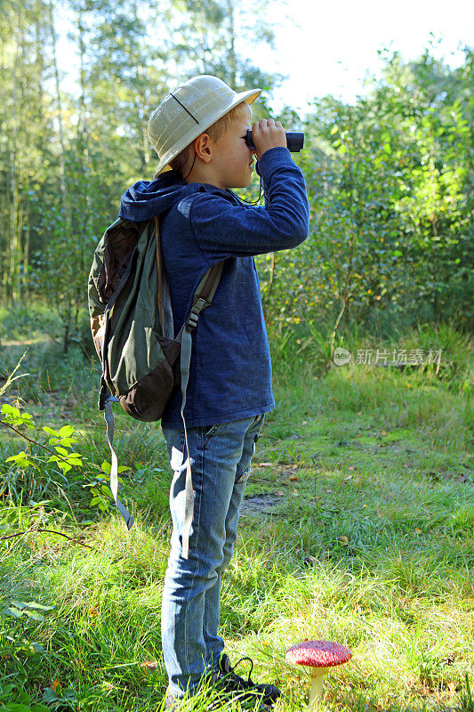 在森林里用望远镜看的男孩