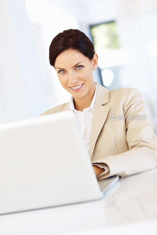 商务女性微笑着使用笔记本电脑