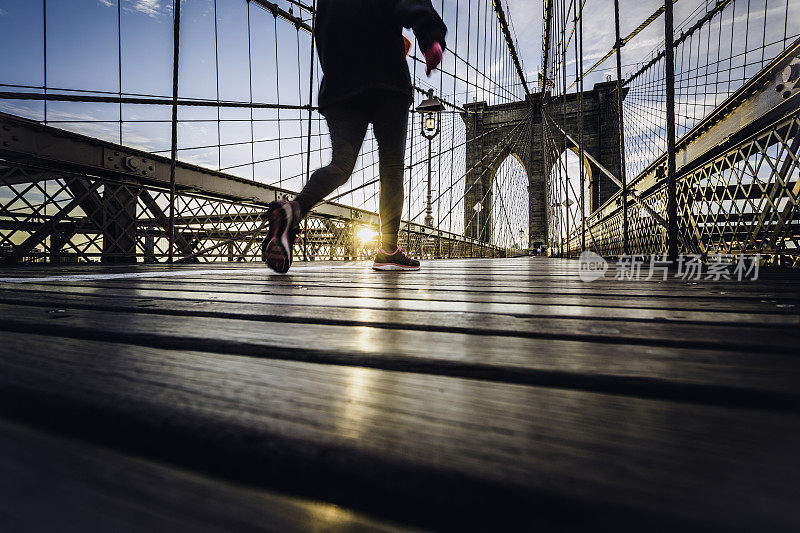 日出时，纽约布鲁克林大桥上的跑步者
