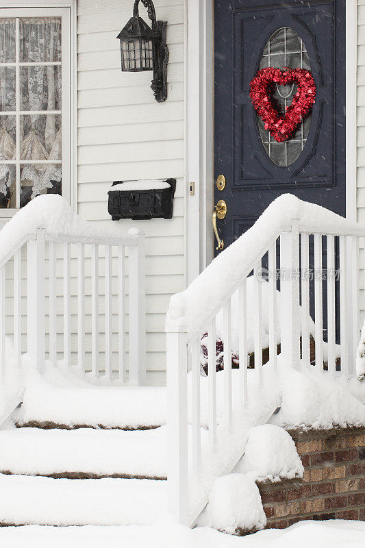 2月的楼梯上飘着雪花，门上挂着情人节的装饰品