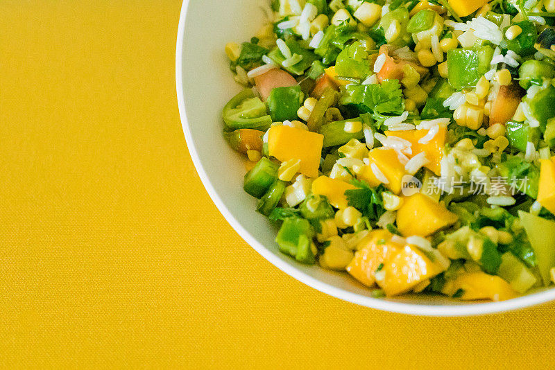 绿色和黄色的仙人掌和芒果沙拉在一个碗里