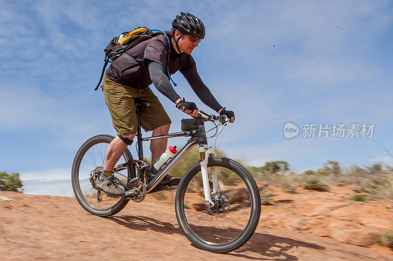山地自行车在犹他州摩押光滑的岩石小径上。