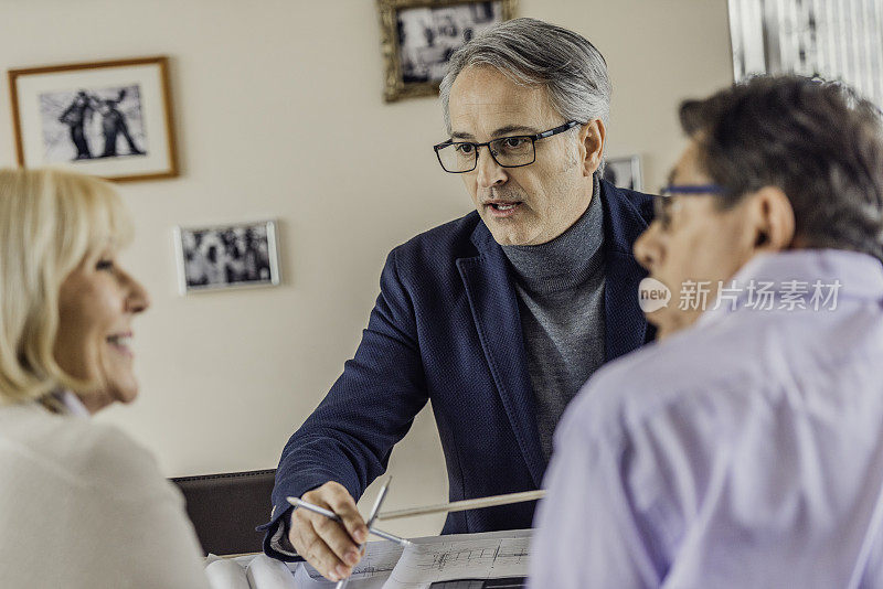 建筑师向一对老年夫妇解释项目计划