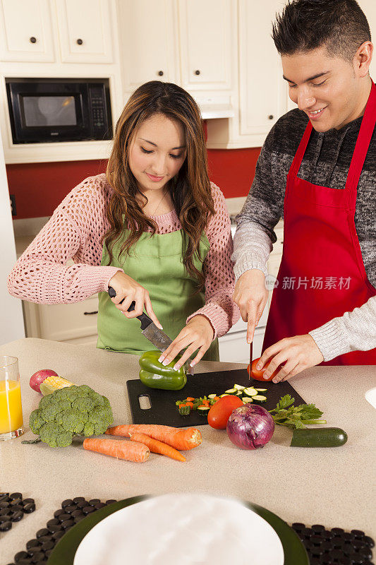 在家庭厨房里一起准备食物的拉丁后裔夫妇。