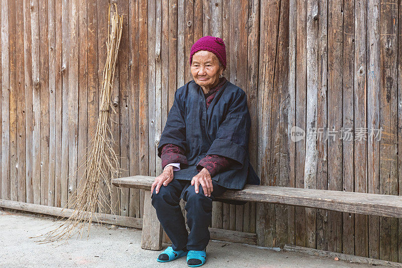 坐在木凳上的侗族妇女