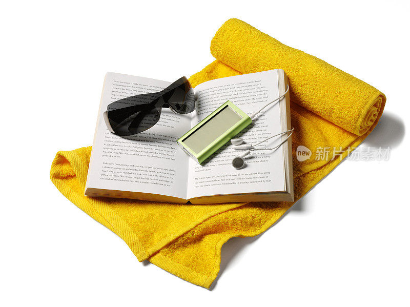 沙滩毛巾上放着书和太阳镜